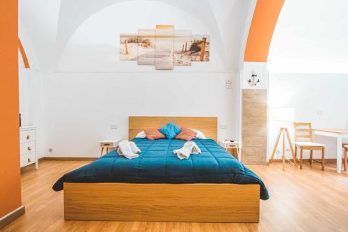 um quarto com uma cama azul e 2 toalhas em Fisherman house em Bari