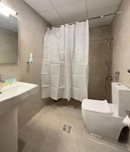 a bathroom with a toilet and a sink and a shower at Sea Shore Hotel Apartment Khorfakkan in Khor Fakkan