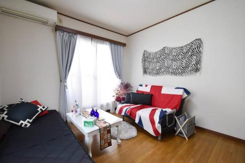 a living room with a bed and a window at アンドステイ中野5丁目203 in Tokyo