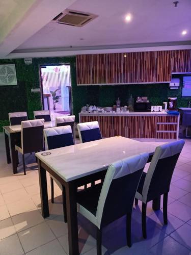 a dining room with a table and chairs and a bar at HOTEL SRI SUTRA (BANDAR SUNWAY) in Petaling Jaya