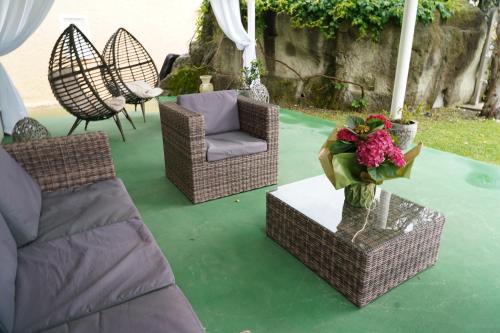 a patio with chairs and a table with a vase of flowers at Hotel Parco Delle Agavi in Ischia