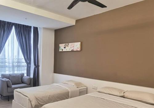 a bedroom with two beds and a chair and a window at Emerald Avenue Cozy 3R3B Apartment 715 in Brinchang