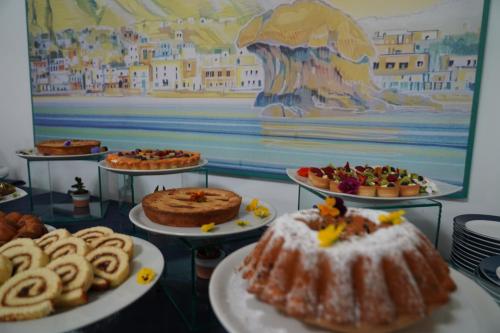 a table with different types of cakes and pastries at Hotel Parco Delle Agavi in Ischia