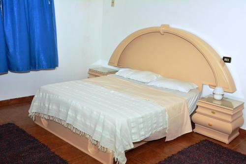a bedroom with a large bed with a large headboard at Villa Belzoni in Luxor
