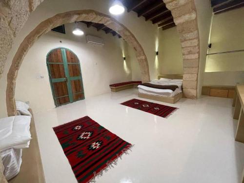a room with two beds and two rugs on the floor at Tafileh-Sila'a Heritage Village in Tufailah