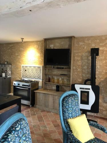 een woonkamer met 2 stoelen en een flatscreen-tv bij La Maison in La Chapelle-Saint-Martin-en-Plaine