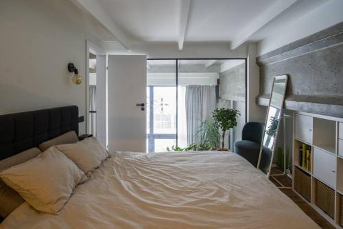 維爾紐斯的住宿－Bright and stylish city centre 1 bedroom loft，一间卧室配有一张大床和一把椅子