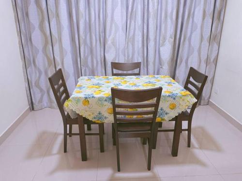 a table with four chairs and a table cloth with flowers at IJM Homestay Condominium in Sandakan