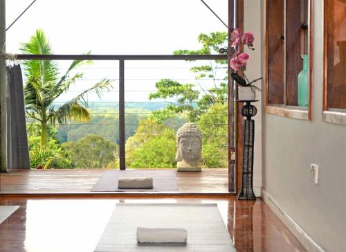 a meditation room with a view of a statue in the window at The Junglehouse Noosa in Doonan