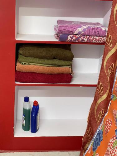 a red closet with towels and cleaning products in it at Pakas House in Kākināda