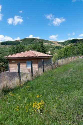 una pequeña casa en una colina con un campo en chalet le cedre, en Saint-Joseph-des-Bancs