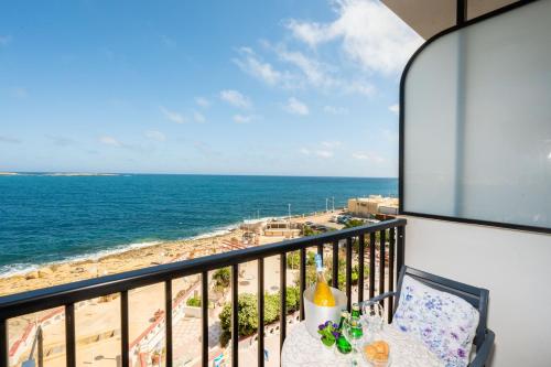 a balcony with a table and a view of the ocean at Islet Promenade Seafront Family Apartment with 2 balconies by Getawaysmalta in St. Paul's Bay