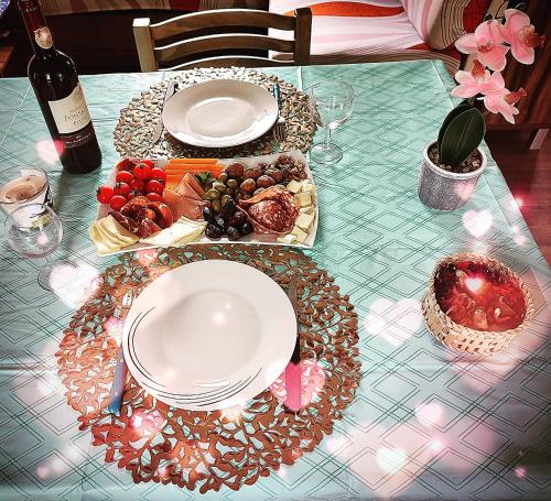 una mesa con platos de comida y una botella de vino en Vacances insolites en Foix