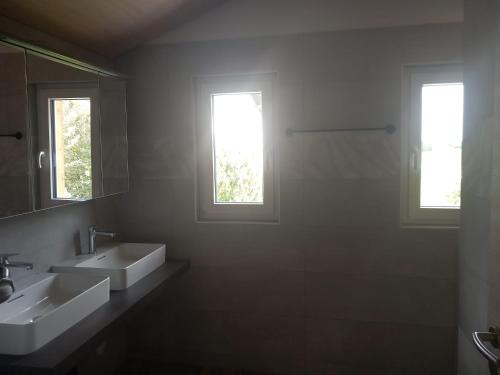 - Baño con 2 lavabos y 2 ventanas en Les P'tits Loups, en Courtedoux