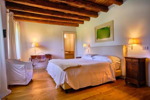 a bedroom with a large bed and a wooden ceiling at Relais Corte Guastalla Apartments in Sona