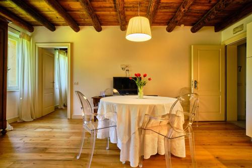 a dining room with a table with a vase of flowers on it at Relais Corte Guastalla Apartments in Sona