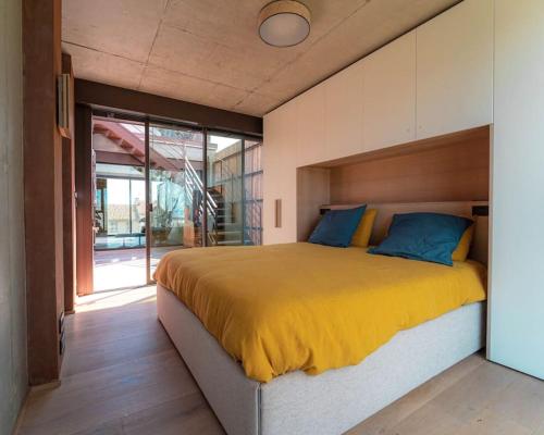 Cette chambre comprend un grand lit avec des draps jaunes et des oreillers bleus. dans l'établissement Villa Ananda 5 étoiles de rêves, à Carnon-Plage