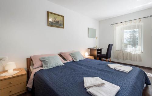 Un dormitorio con una cama azul con toallas. en 3 Bedroom Awesome Home In Jurdani en Jurdani