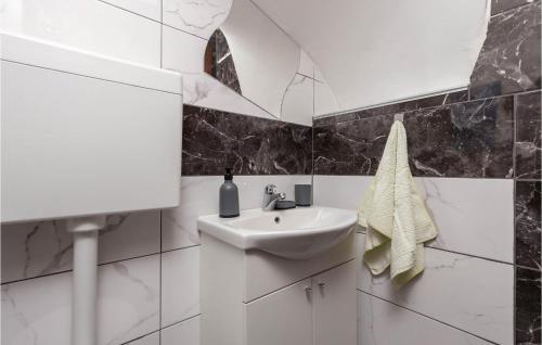 La salle de bains blanche est pourvue d'un lavabo et d'un miroir. dans l'établissement 3 Bedroom Awesome Home In Jurdani, à Jurdani