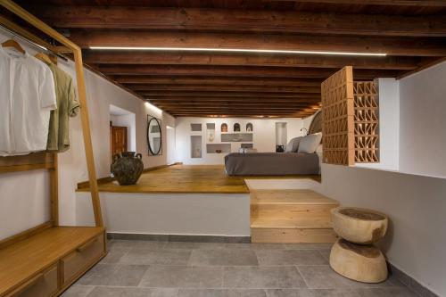 een slaapkamer met een bed in een kamer met houten plafonds bij Pera houses 2-bedroom in the center of Lindos in Lindos
