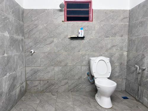 a bathroom with a toilet and a window at Padang Besar White House Homestay in Padang Besar