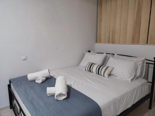 1 dormitorio con 1 cama con toallas en Captain's Mermaid Houses, Karpathos, en Karpathos