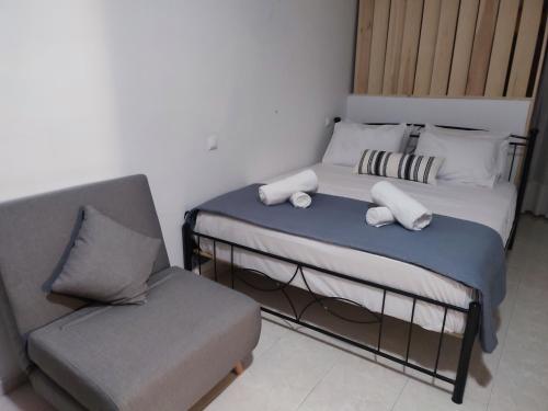una piccola camera con letto e sedia di Captain's Mermaid Houses, Karpathos a Karpathos