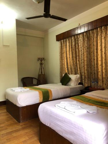 a bedroom with two beds and a ceiling fan at Bouddha Green Hotel in Kathmandu