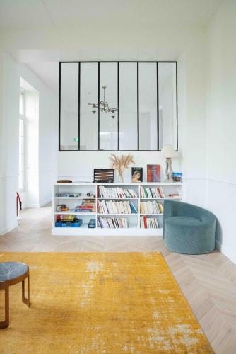 a living room with a blue chair and a book shelf at Château De La Bûcherie in Saint-Cyr-en-Arthies