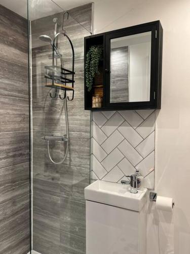 a bathroom with a shower and a sink and a mirror at Cherry Blossom cottage in Old Glossop