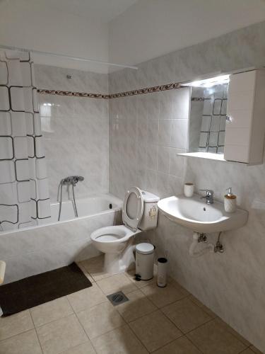 a bathroom with a toilet and a tub and a sink at Airport city center 2 in Spata