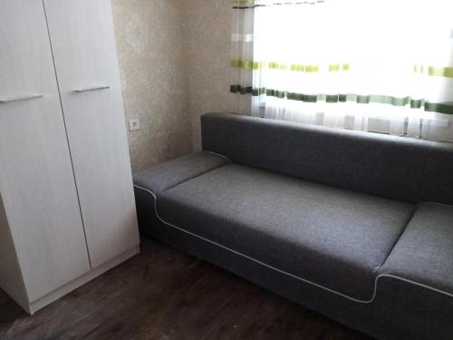 ein Sofa in einem Zimmer mit Fenster in der Unterkunft Гостевой Дом in Qysylorda