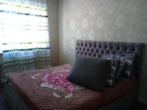 a bedroom with a bed with pink flowers on it at Гостевой Дом in Qyzylorda