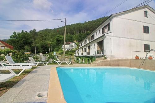 a house with a swimming pool next to a building at Serrana Gerês in Geres