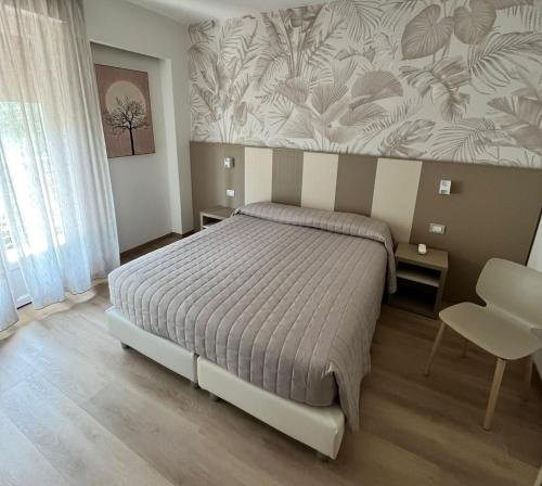 a bedroom with a bed and a wall with flowers at Eco Hotel Ariston in Malcesine
