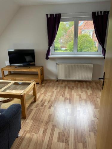 a living room with a wooden floor and a large window at Ferienwohnung Friedrich Dorfmark in Bad Fallingbostel