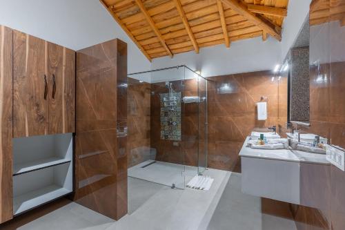a bathroom with a shower and a sink at Vibhasa-The Scenic Solitude Villa Amidst Himalayas Near Kainchi Dham-Where BBQ and Bonfires Ignite the Adventure in Rāmgarh