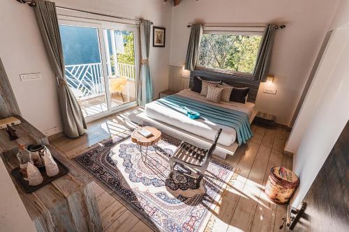 a bedroom with a bed and a large window at Vibhasa-The Scenic Solitude Villa Amidst Himalayas Near Kainchi Dham-Where BBQ and Bonfires Ignite the Adventure in Rāmgarh