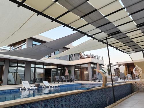 una casa con piscina con techo en The Legend Villa فيلا الاسطوره, en Sowayma