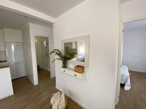 a white room with a mirror and a plant on a table at Apartamento Paradis con encanto y vistas al mar in Vinaròs