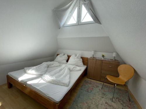 a bedroom with a bed with white sheets and a window at Mine Heimat _ Dat Roeverhus_ in Zingst