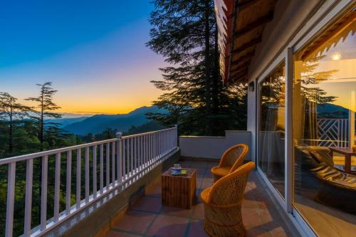 a balcony with chairs and a view of the mountains at Vibhasa-The Scenic Solitude Villa Amidst Himalayas Near Kainchi Dham-Where BBQ and Bonfires Ignite the Adventure in Rāmgarh