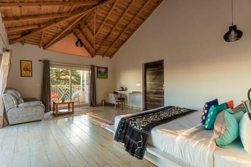 a bedroom with a bed and a living room at Vibhasa-The Scenic Solitude Villa Amidst Himalayas Near Kainchi Dham-Where BBQ and Bonfires Ignite the Adventure in Rāmgarh