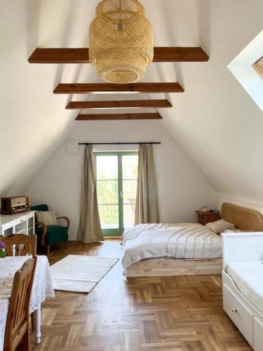a attic room with a bed and a window at Csendár Cottage Balaton in Hegymagas