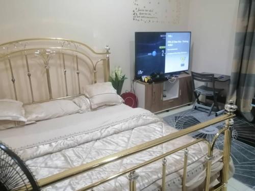 - une chambre avec un lit et une télévision à écran plat dans l'établissement serene luxury master bedroom, à Charjah
