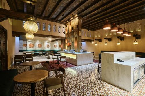 a restaurant with tables and chairs and a bar at Kosh Havuz boutique hotel in Samarkand