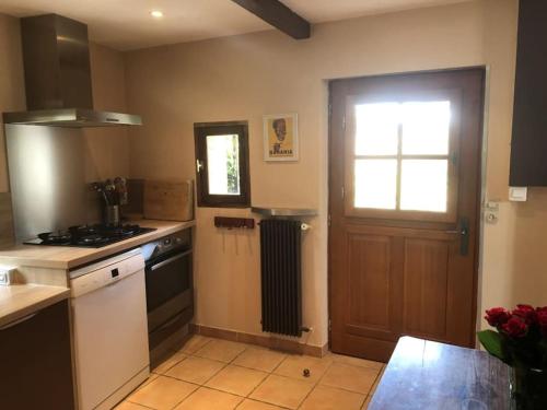 d'une cuisine avec cuisinière et d'une porte avec fenêtre. dans l'établissement Petite Maison de Charme, à Vence