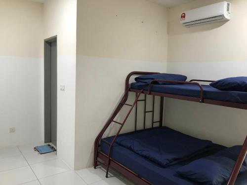a room with two bunk beds and a air conditioner at AZ HomeStay Bandar Puncak Alam in Bandar Puncak Alam