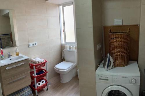 a bathroom with a toilet and a washing machine at apartamento precioso y coqueto in Seville