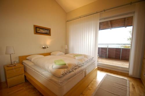 a bedroom with a large white bed with a window at Penthouse Bruckberg by Four Seasons Apartments in Zell am See